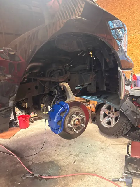 Front suspension and freshly painted blue brake caliper